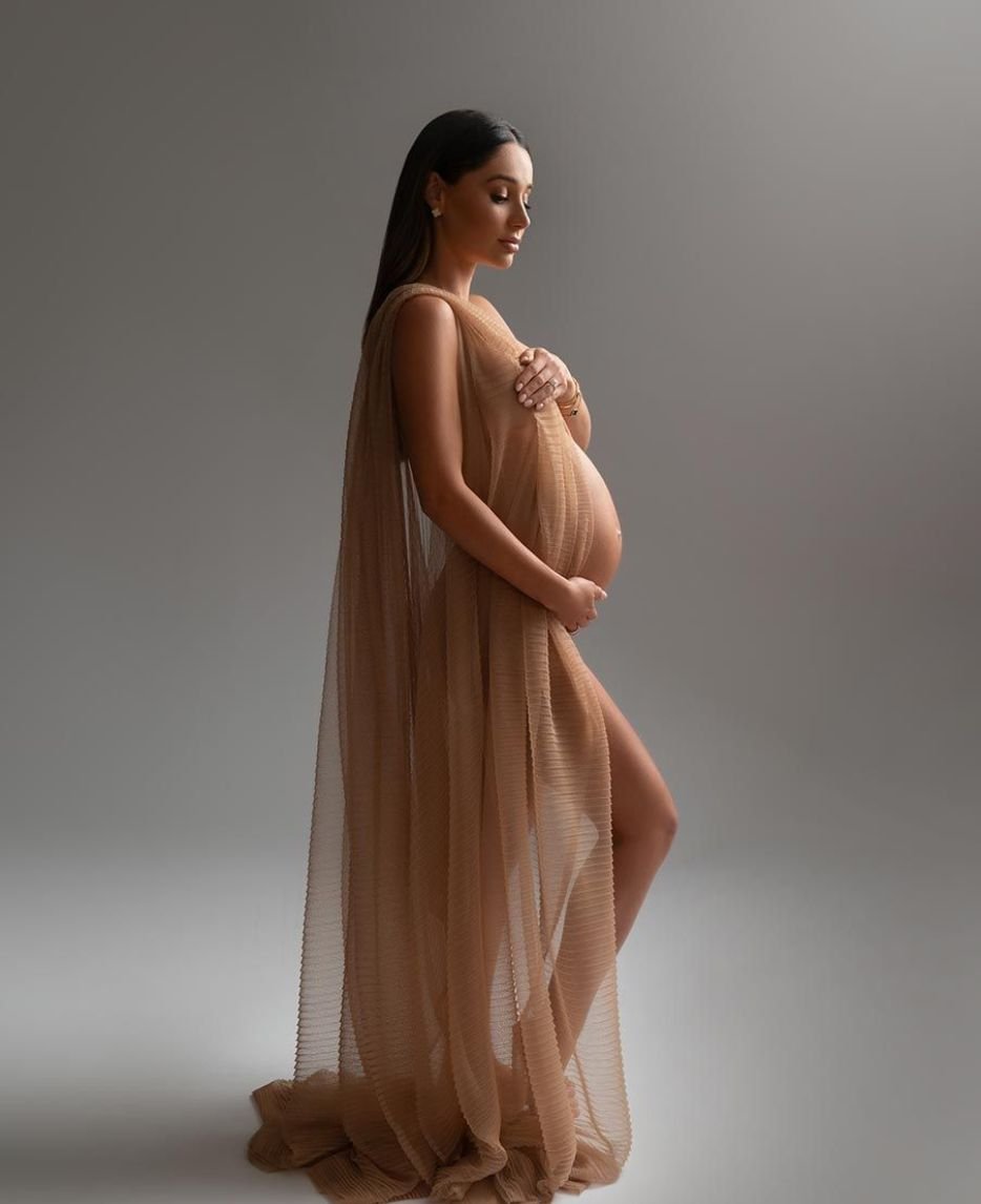 A maternity photoshoot titled "Mrs MILK" features aerial shots of a pregnant woman, emphasizing the beauty of her baby bump from above.