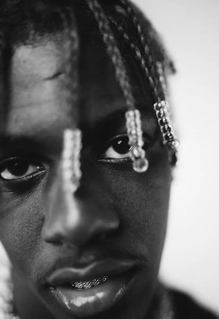 A black and white image featuring a man with dreadlocks, showcasing his unique hairstyle and expression.