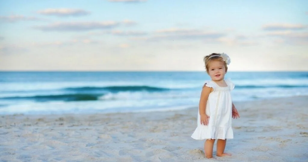 Little girl playing on the beach, capturing joyful and magical moments in natural sunlight.