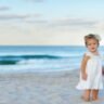 Little girl playing on the beach, capturing joyful and magical moments in natural sunlight.