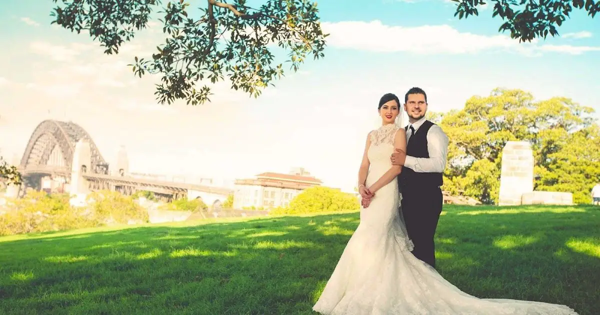 Couple posing with Sydney Opera House in the background, showcasing a professional wedding photographer capturing the moment.