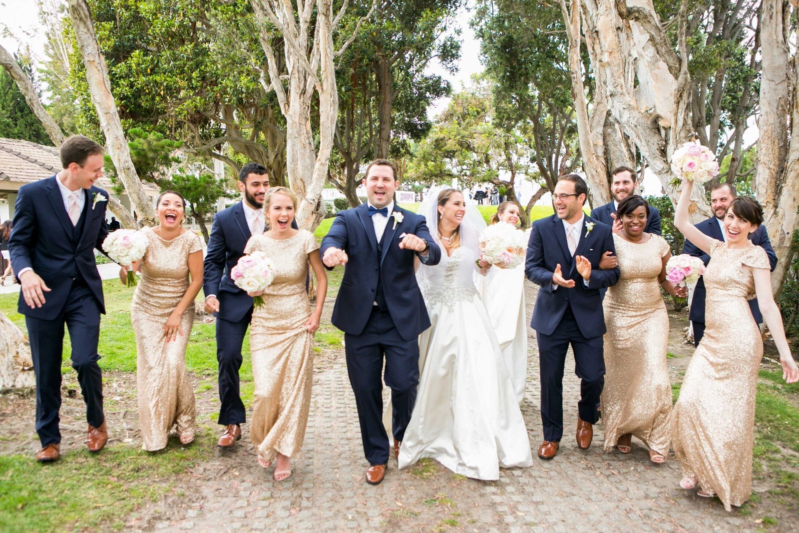 Wedding party walking together in coordinated outfits, enjoying a joyful moment.