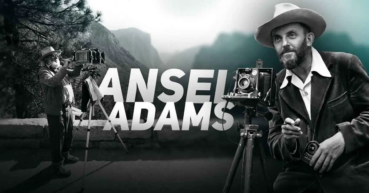 The iconic photographer Ansel Adams poses in front of his camera, symbolizing his dedication to landscape photography.