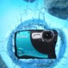 A submerged Arti Waterproof camera surrounded by rocks, capturing the underwater scene in clear detail.