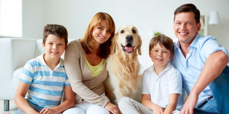 A family and their dog are seated on the floor, sharing a loving moment during a fun photoshoot.