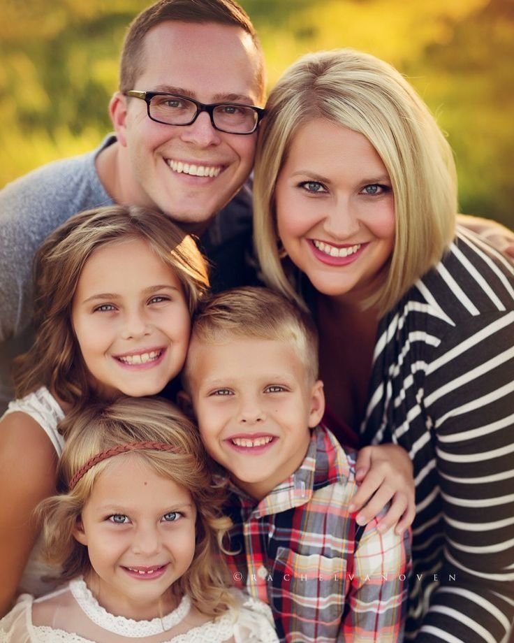 A joyful family poses in a vibrant field, showcasing various photography props for a memorable photo.