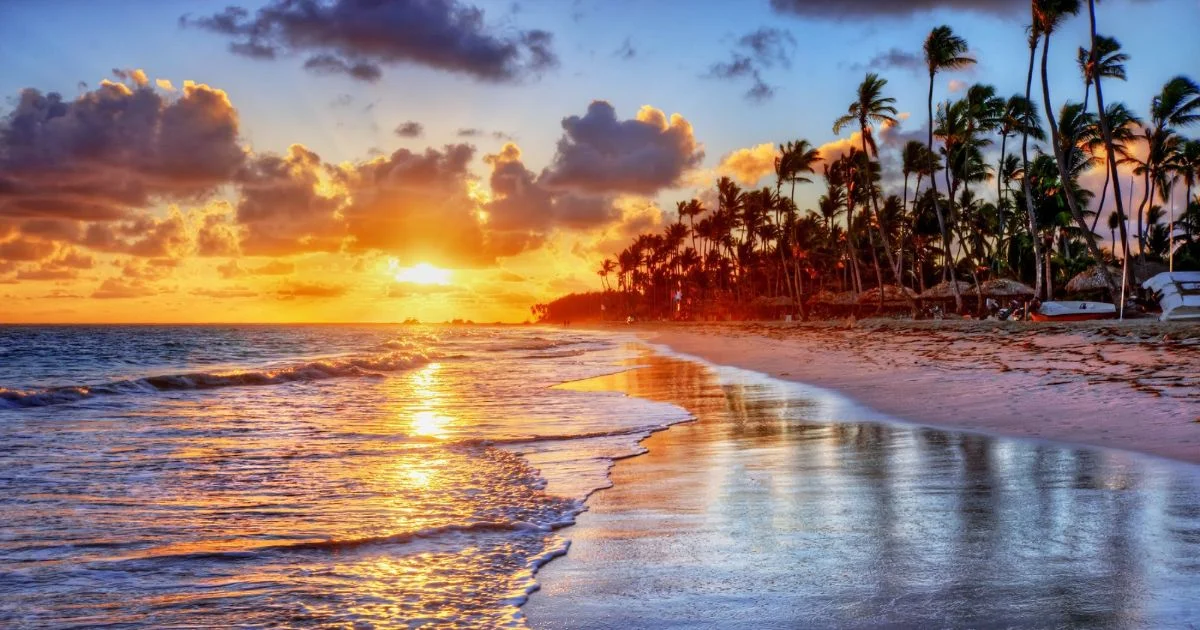 The sun sets gracefully over the ocean, illuminating the beach with vibrant colors, a stunning moment in sunset photography.