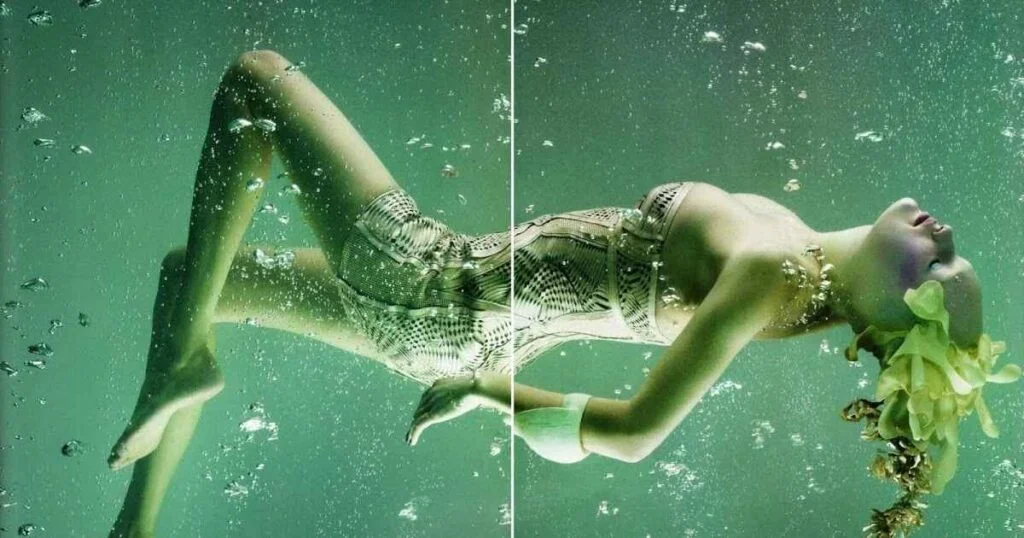 A woman in a green dress gracefully floats in the water, embodying the essence of mermaid photography.