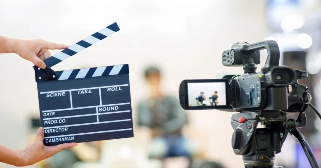 A person holds a video camera and clapper board, embodying the essence of SDXL film photography in action.