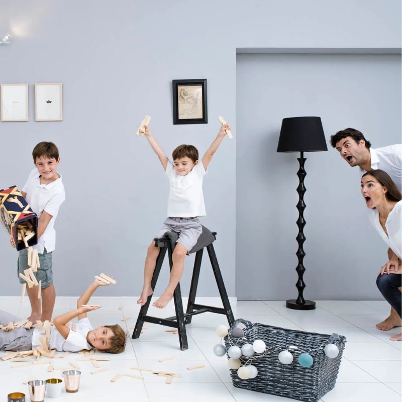 A family joyfully playing with colorful toys in a well-decorated room filled with photography props.