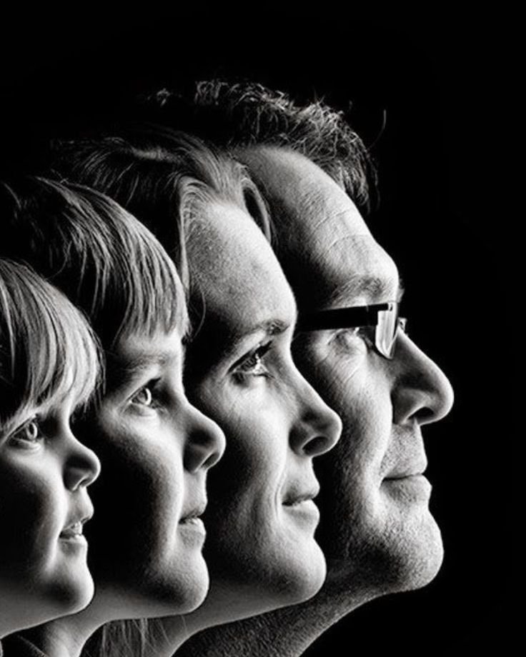 A black and white family portrait featuring various photography props, capturing a moment of togetherness and joy.