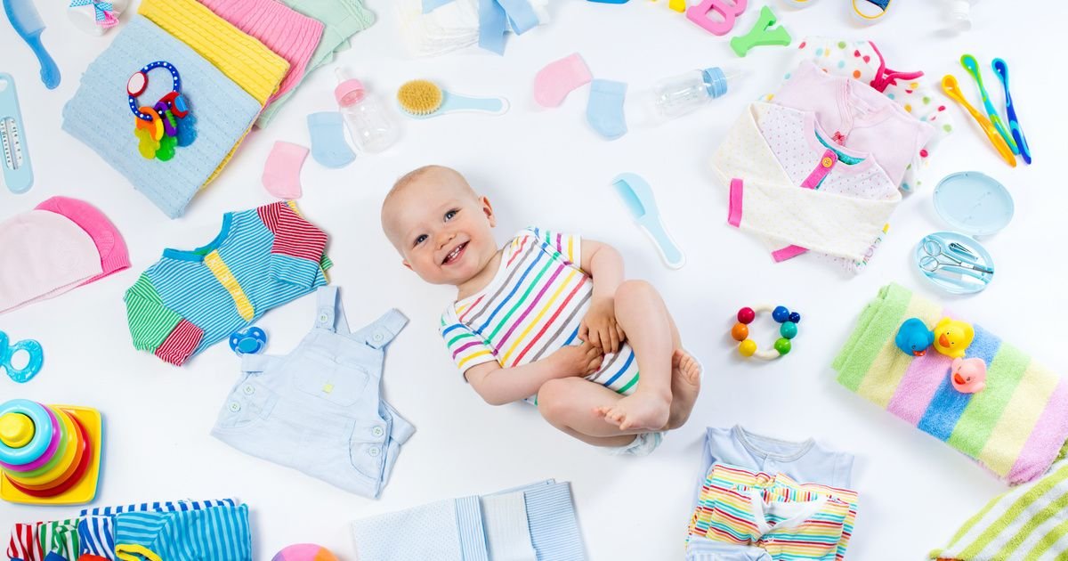 A baby nestled among colorful photography props and various baby items, creating a cozy and playful scene.