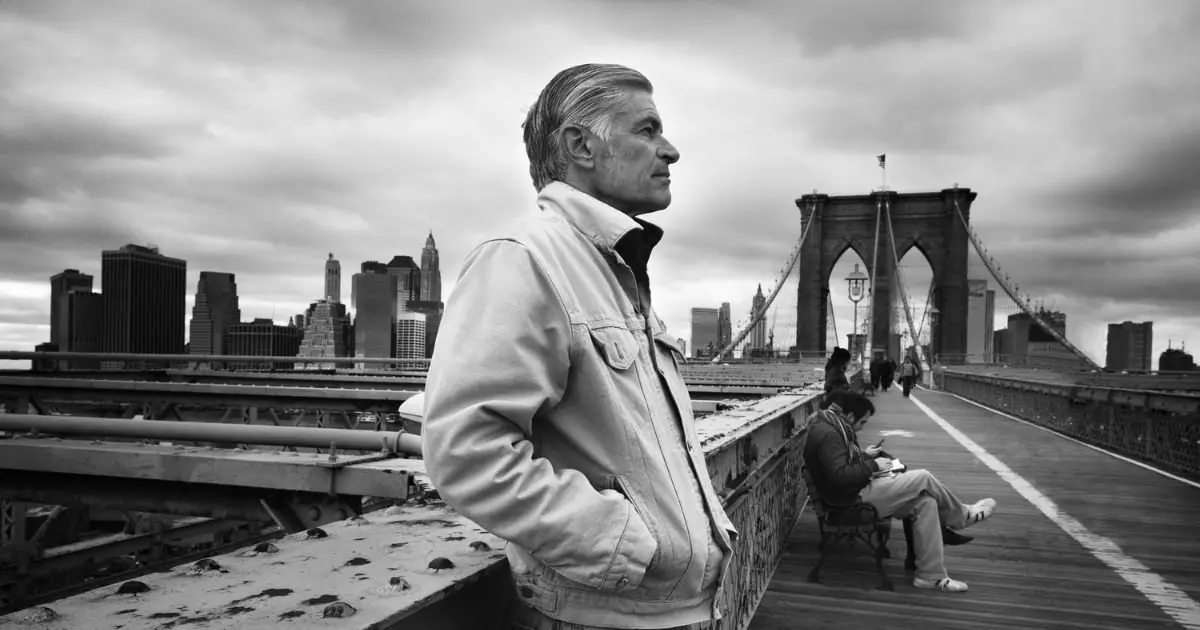 A man on a bridge gazes at the cityscape, reflecting the legacy of famous war photographers.